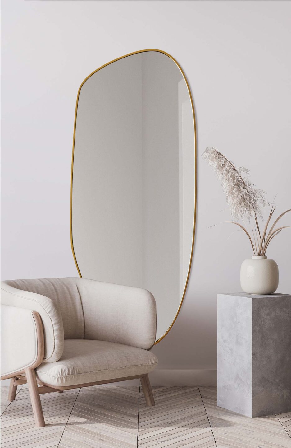 lustro o organicznym kształcie w złotej ramie przy beżowym fotelu