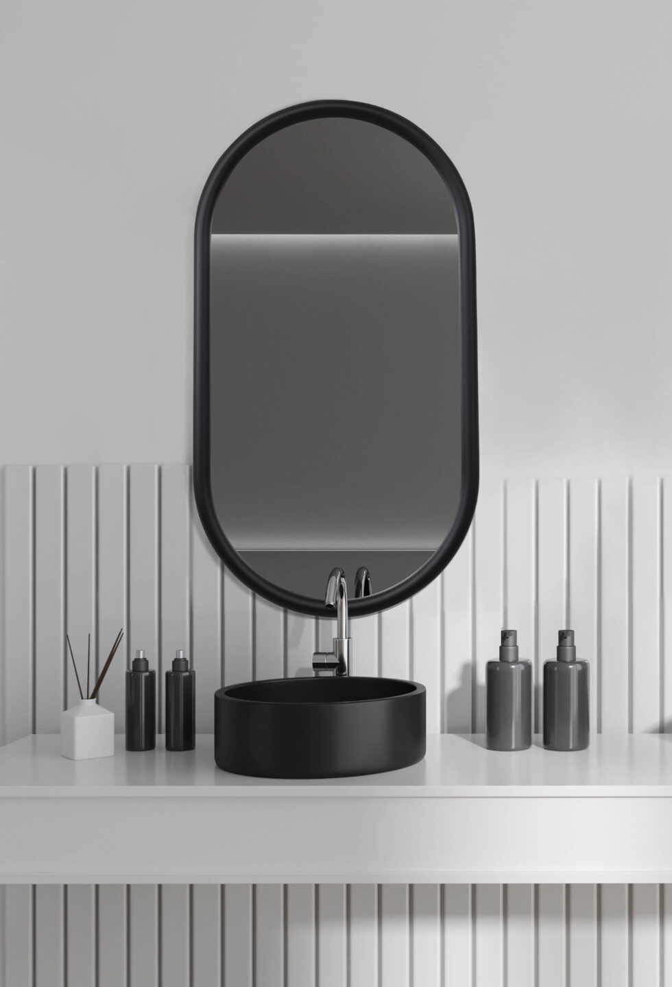 minimalistyczna łazienka z czarną umywalką i owalnym lustrem
